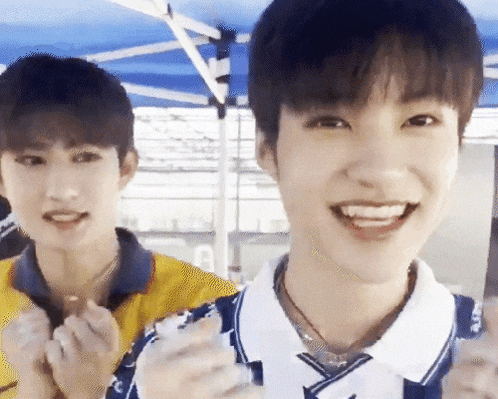 two young men are standing next to each other and smiling for the camera
