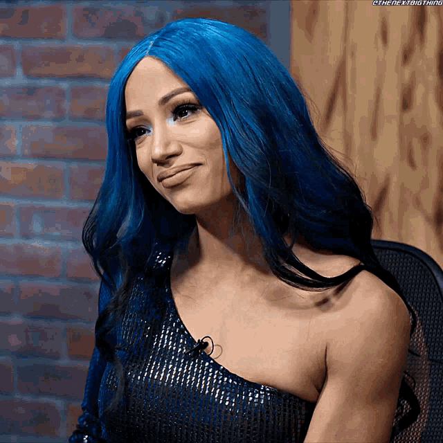 a woman with blue hair is wearing a black top