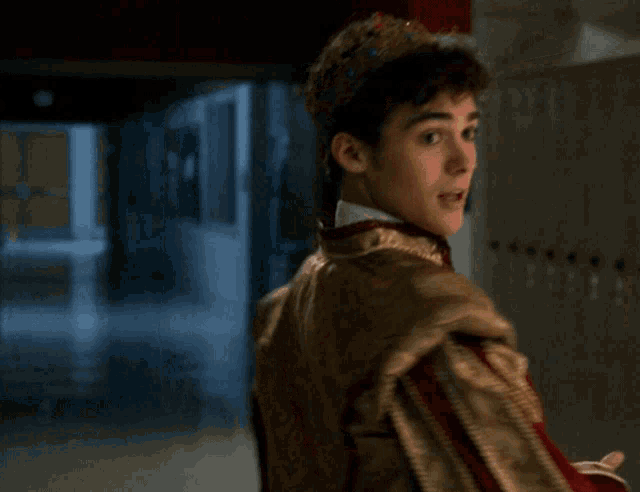 a young man in a costume is standing in a hallway