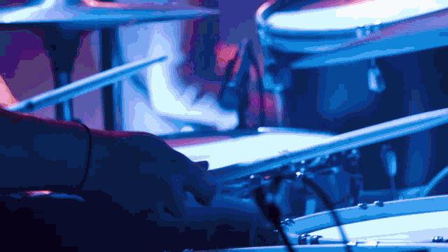 a person playing a drum set with a blue background