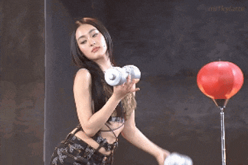 a woman is holding a pair of dumbbells next to a red lantern