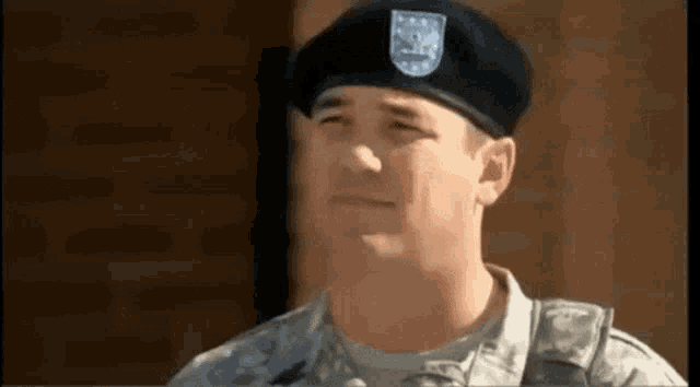 a close up of a soldier wearing a black beret .