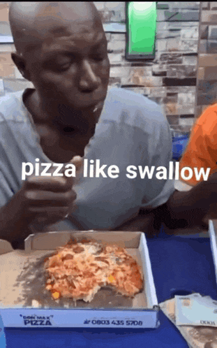 a man is eating pizza from a box that says pizza