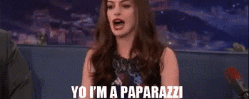 a woman is sitting on a couch talking into a microphone and says `` yo i 'm a paparazzi ''
