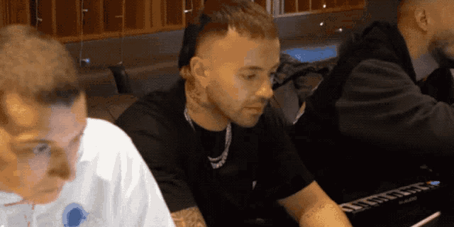 a man in a black shirt has a tattoo on his wrist that says ' i love you '