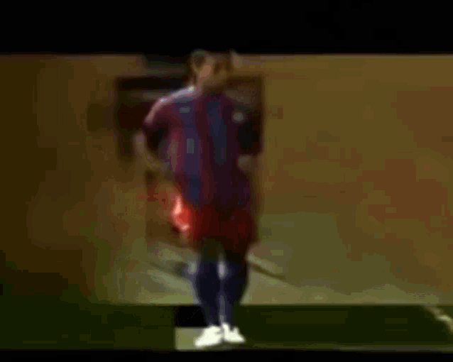 a blurry picture of a soccer player in a red and blue jersey