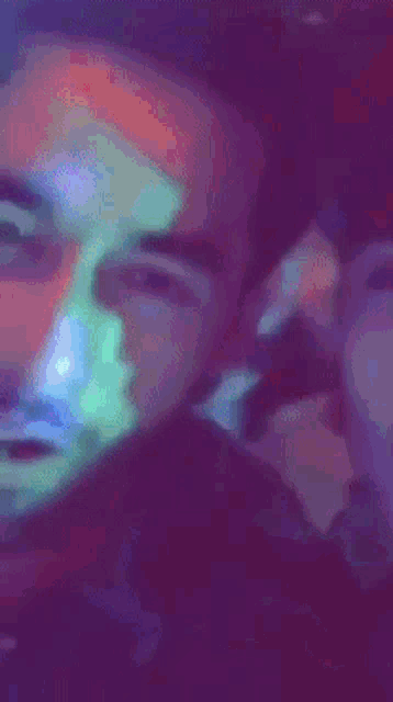 a close up of a man 's face with a rainbow of colors on it
