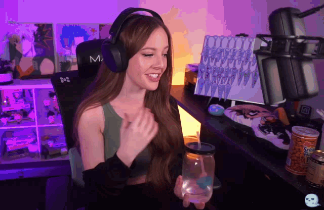 a woman wearing headphones and holding a glass of water