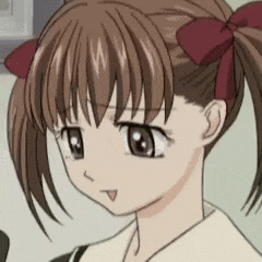 a close up of a girl 's face with pigtails and a red bow in her hair .