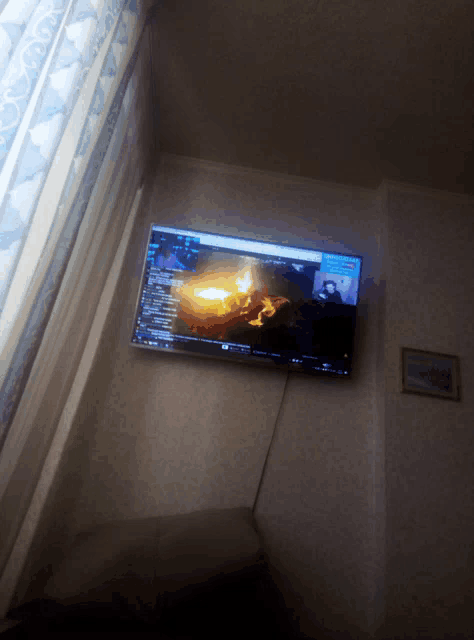 a flat screen tv is turned on and shows a fire