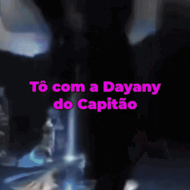 a person is smoking a hookah in a dark room with the words to com a dayany do capitao written in pink