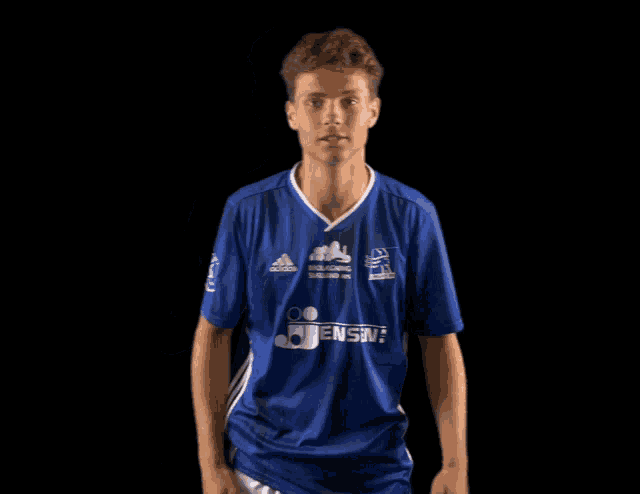 a young man wearing a blue adidas shirt with jensen on it