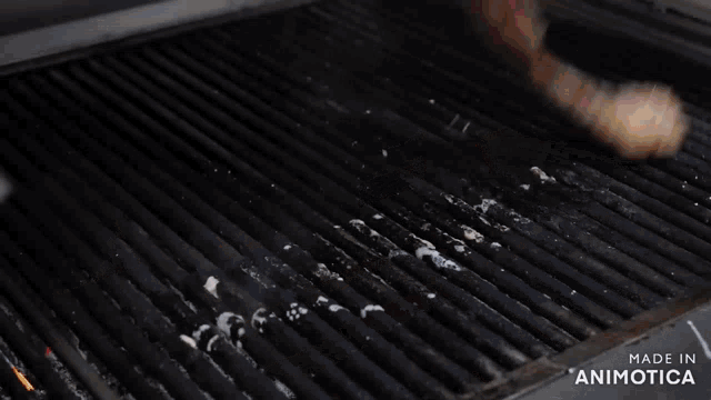 a piece of meat is being cooked on a grill with the words made in animotica above it