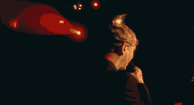 a man singing into a microphone with a crowd behind him