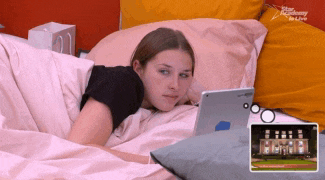 a woman laying on a bed looking at a tablet with the words star academy in live on the bottom