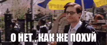 a man wearing glasses is walking down a street with a sign in the background that says tfr