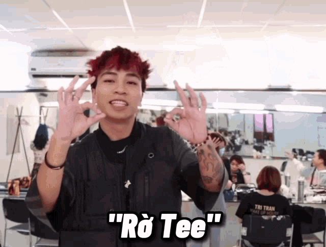 a man with red hair is giving the ok sign and says " ro tee " on the bottom