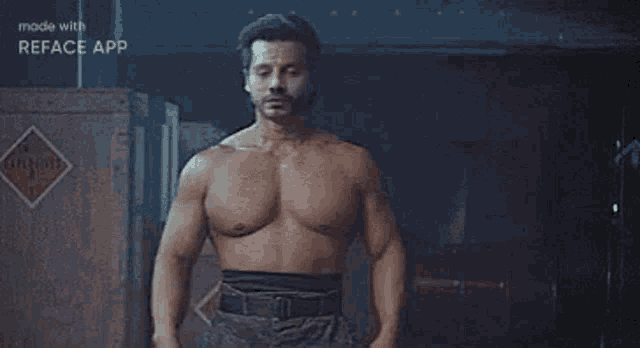 a shirtless man is standing in front of a crate in a dark room .