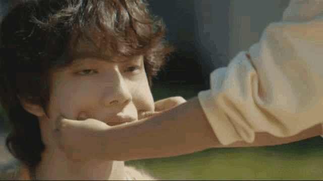 a close up of a person holding another person 's hand to their face