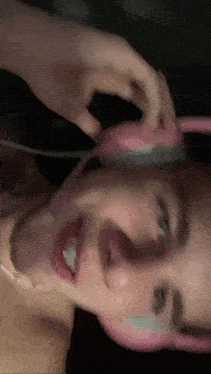 a close up of a person wearing pink bunny ears headphones