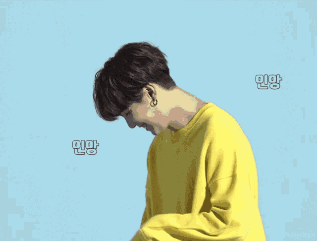a person wearing a yellow sweater with a blue background and the word sugaky on the bottom right