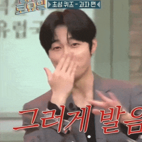 a man in a suit is covering his mouth with his hands in a foreign language