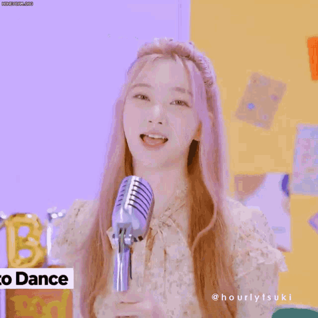 a girl with pink hair stands in front of a microphone with the words " to dance " on the bottom