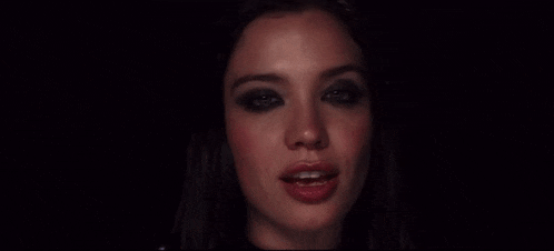 a close up of a woman 's face with black eyeshadow