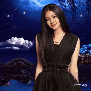 a woman in a black dress is standing in front of a blue sky with clouds