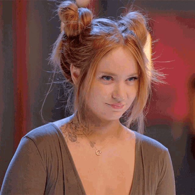 a woman with red hair and a tattoo on her shoulder