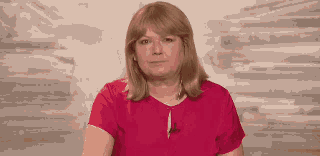 a woman in a red shirt with a microphone in her neck
