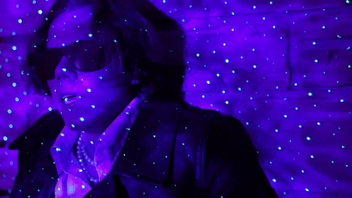 a man wearing sunglasses is surrounded by glowing lights