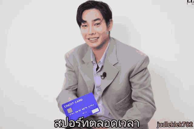 a man in a suit is holding a credit card with the number 1234 on it