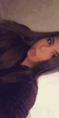a woman with long hair is sticking her tongue out .