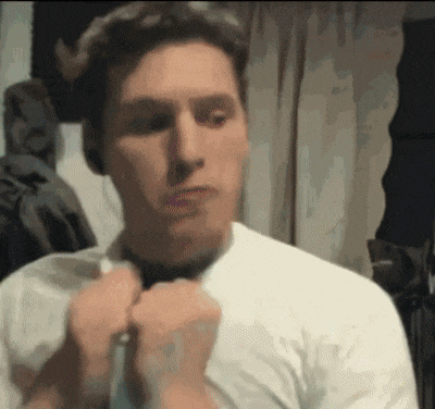 a man in a white shirt is tying a tie