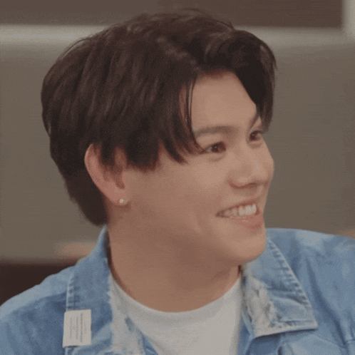 a young man wearing a blue jacket and a white shirt smiles