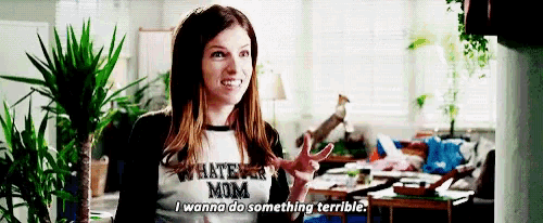 a woman is wearing a t-shirt that says `` whatever mom '' and making a peace sign .