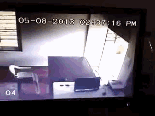 a tv screen shows a room with a desk and chair and a time of 02:37:16 pm
