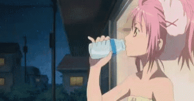 a girl with pink hair is drinking water from a bottle at night .