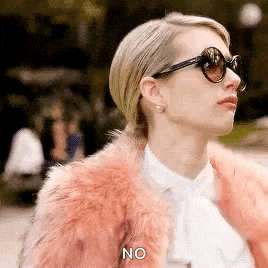 a woman wearing sunglasses and a pink fur coat is talking .