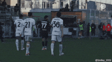 a soccer player wearing the number 36 jersey holds up his hand