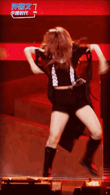 a woman is dancing in front of a sign that says ' a ' on it