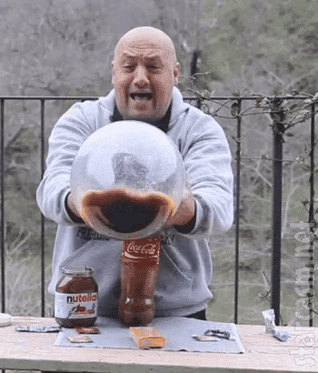 a bald man is holding a bottle of coca-cola and a jar of nutella