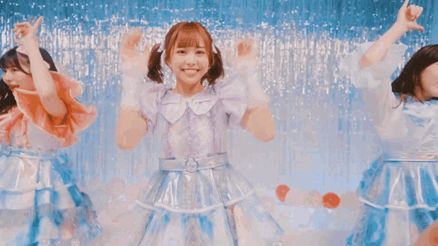 a group of girls are dancing together in front of a blue background