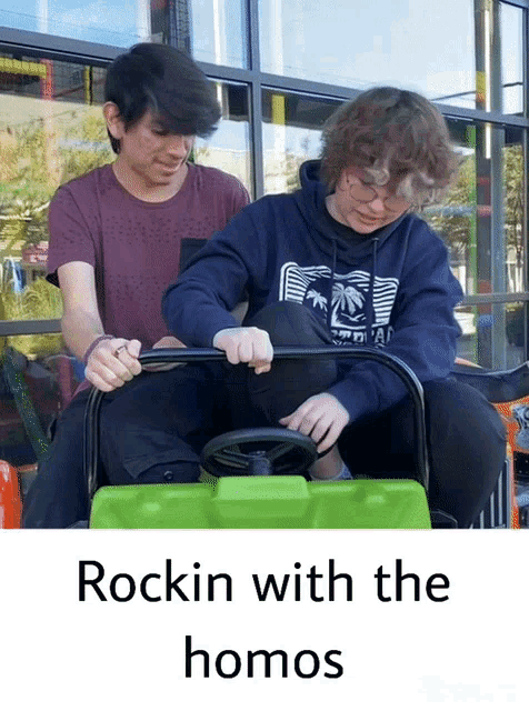 two young men are riding a green toy car with the words rockin with the homos on the bottom