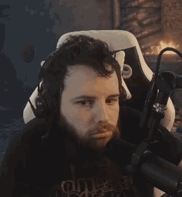 a man with a beard is wearing headphones and a microphone .