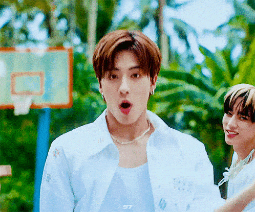 a man with a surprised look on his face is standing next to a basketball hoop .