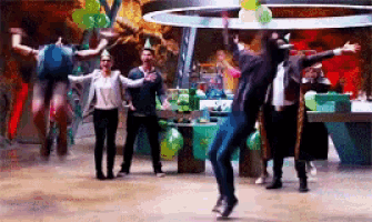 a group of people are dancing in a room with balloons on the floor