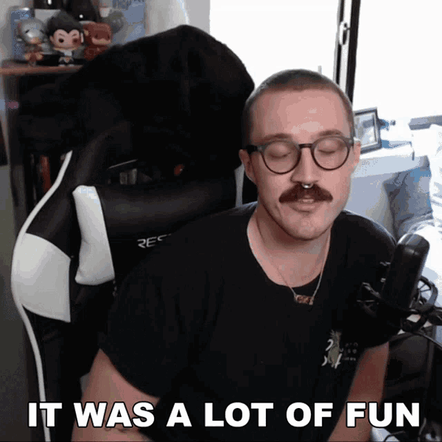 a man with glasses and a mustache is sitting in a chair and says it was a lot of fun