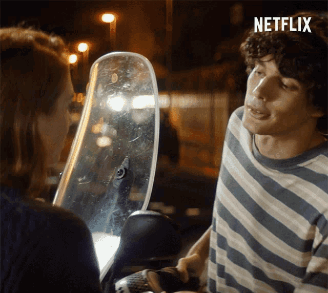 a man and a woman are looking at each other with a netflix logo above them